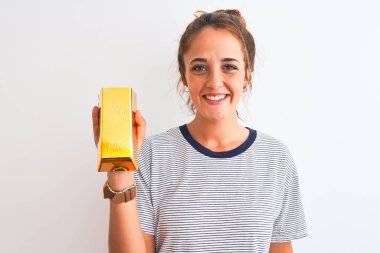 Güzel, kızıl saçlı, altın külçeli bir kadını izole edilmiş arka planda tutan mutlu bir yüzü olan, kendine güvenen bir gülümsemesi olan, dişlerini gösteren bir kadın.