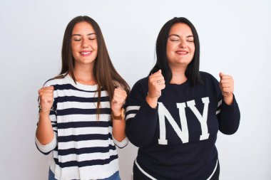 Young beautiful women wearing casual clothes standing over isolated white background excited for success with arms raised and eyes closed celebrating victory smiling. Winner concept.