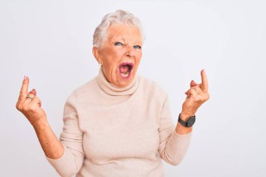 Senior grey-haired woman wearing turtleneck sweater standing over isolated white background Showing middle finger doing fuck you bad expression, provocation and rude attitude. Screaming excited