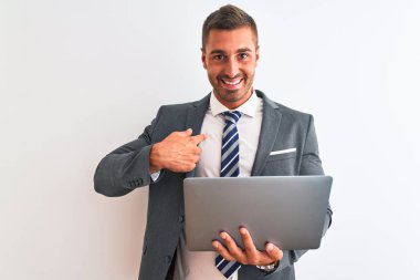 Genç yakışıklı iş adamı bilgisayarını kullanarak izole edilmiş arka planda çalışıyor. Şaşırmış yüz ifadesi kendini gösteriyor.