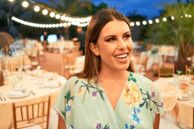 Parti şöleninde mutlu ve neşeli gülümseyen gelinlikli güzel ve zarif bir kadın.