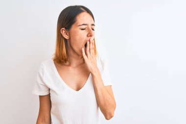 Beautiful redhead woman wearing casual white t-shirt over isolated background bored yawning tired covering mouth with hand. Restless and sleepiness.