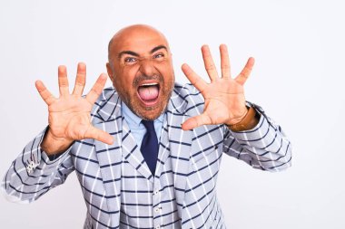 İzole edilmiş beyaz arka planda duran takım elbiseli orta yaşlı bir işadamı on numarayı gösterip işaret ederken kendinden emin ve mutlu bir şekilde gülümsüyor..