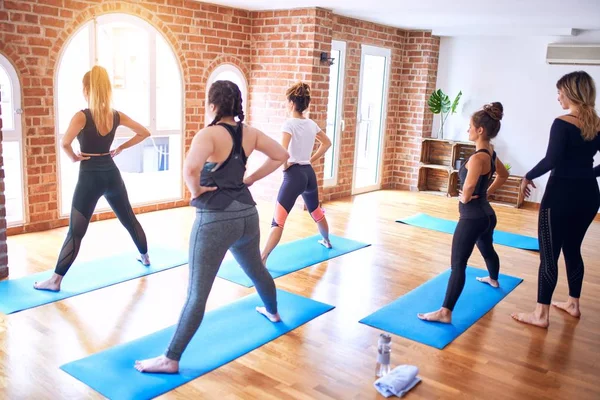 年轻美丽的一群女运动员正在练瑜伽 教练在体育馆为女运动员授课 — 图库照片