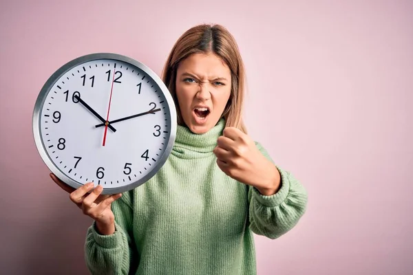 Joven Hermosa Mujer Sosteniendo Reloj Pie Sobre Fondo Rosa Aislado —  Fotos de Stock