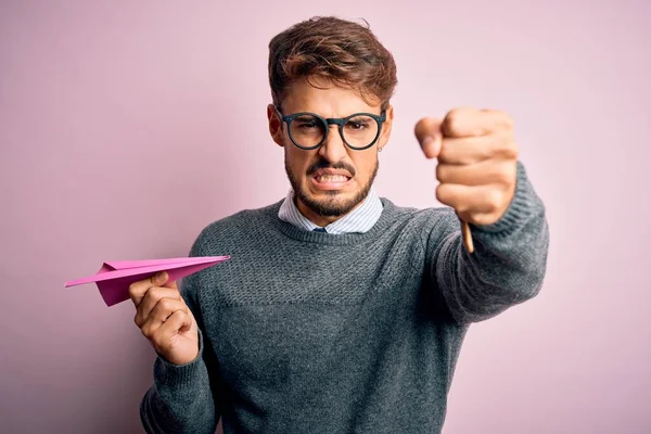 Young Handsome Man Holding Paper Aircraft Wearing Glasses Isolated Pink — Stok fotoğraf