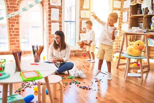 Hermosa Maestra Niños Pequeños Jugando Alrededor Montón Juguetes Jardín Infantes — Foto de Stock