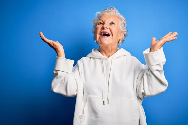 Senior Beautiful Sporty Woman Wearing White Sweatshirt Isolated Blue Background — Stok fotoğraf