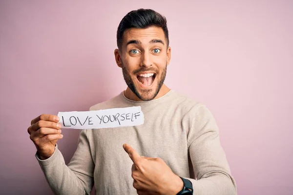 Jovem Homem Bonito Segurando Papel Com Mensagem Amor Sobre Fundo — Fotografia de Stock