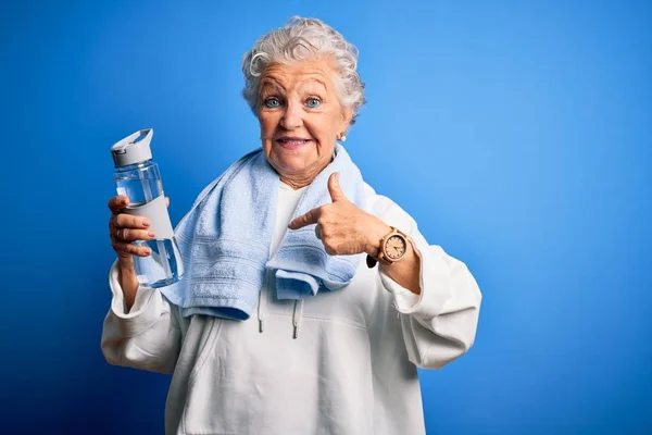 Senior Beautiful Sporty Woman Holding Bottle Water Standing Isolated Blue — Stock Photo, Image