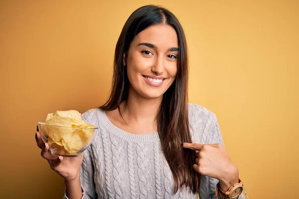 Young Beautiful Brunette Woman Holding Bowl Snack Potato Chips Yellow — Stockfoto