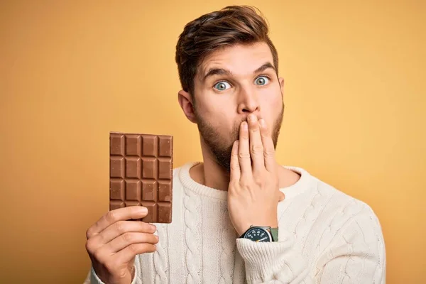 Jovem Loiro Com Barba Olhos Azuis Segurando Barra Chocolate Sobre — Fotografia de Stock