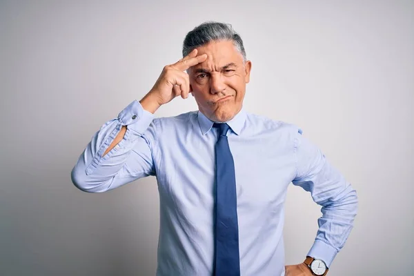 Middle age handsome grey-haired business man wearing elegant shirt and tie worried and stressed about a problem with hand on forehead, nervous and anxious for crisis