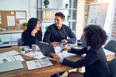 Group of business workers smiling happy and confident. Working together with smile on face reading documents and  speaking at the office