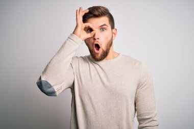 Sakallı, mavi gözlü, sıradan bir süveter giyen, şaşırmış yüzüyle, parmaklarından bakan genç, yakışıklı sarışın bir adam. İnançsız ifade.