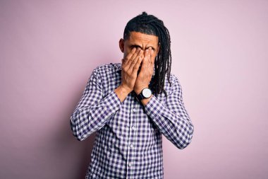 Rastgele gömlek giyen, yorgun ve yorgun bir ifade takınan yorgun ve uykulu bakışları olan Afro-Amerikan genç yakışıklı adam. Görüş sorunu