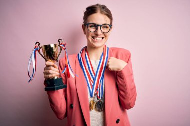 Pembe arka planda madalyalar takan güzel, kızıl saçlı bir kadın kendini gösteren sürpriz bir yüzle.