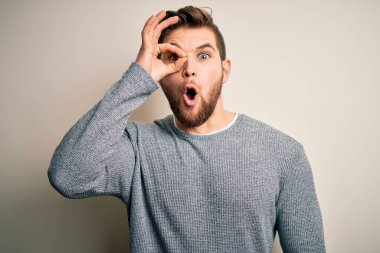 Sakallı, mavi gözlü, sıradan bir süveter giyen, şaşırmış yüzüyle, parmaklarından bakan genç, yakışıklı sarışın bir adam. İnançsız ifade.