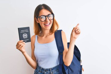 Güzel, kızıl saçlı, sırt çantası takan ve elinde pasaport tutan bir kız öğrenci.