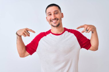 Soyutlanmış arka planda duran genç yakışıklı adam. Kendine güvenen, yüzünde gülümseme olan, kendini gururlu ve mutlu gösteren adam..