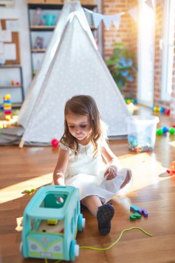 Anaokulunda oyuncak oyuncaklarıyla oynayan sevimli sarışın çocuk.