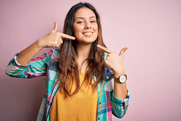 Młoda Piękna Brunetka Ubrana Luźną Kolorową Koszulę Stojąca Nad Różowym — Zdjęcie stockowe