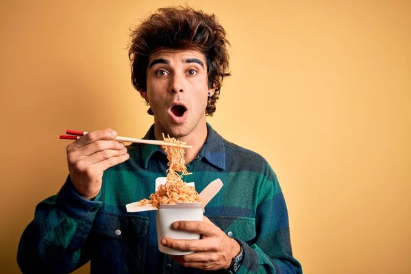 Ung Stilig Man Äter Nudlar Stående Över Isolerad Gul Bakgrund — Stockfoto