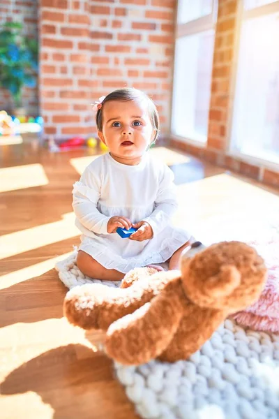 在五彩缤纷的玩具旁的幼儿园里快乐的漂亮婴儿 — 图库照片