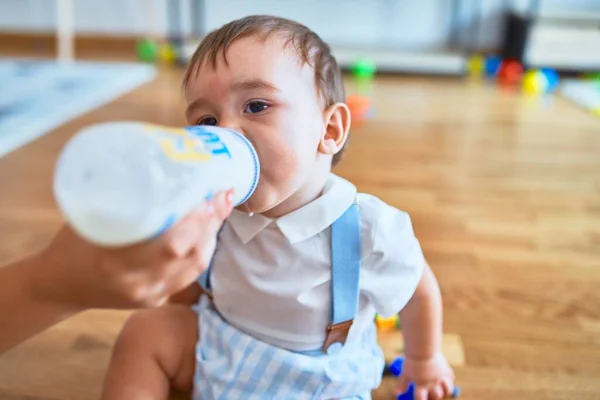 Förtjusande Barn Som Sitter Golvet Och Dricker Mjölk Med Hjälp — Stockfoto