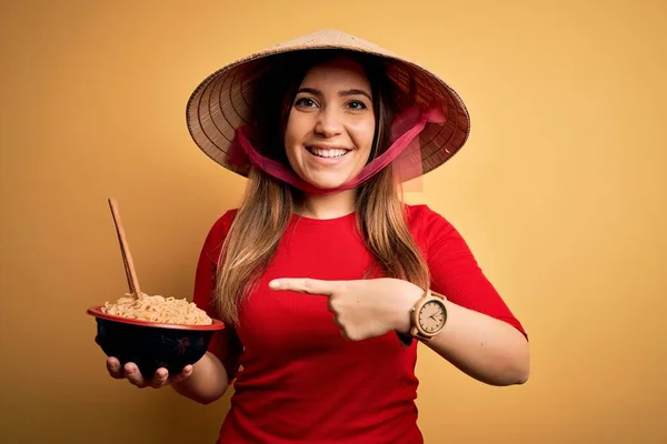 Asya Şapkası Takan Sarı Izole Arka Planda Çin Eriştesi Yiyen — Stok fotoğraf