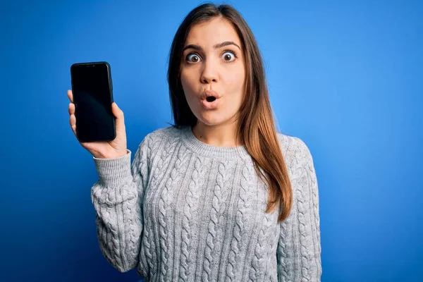 Young Woman Showing Blank Smartphone Screen Blue Isolated Background Scared — Stock Photo, Image