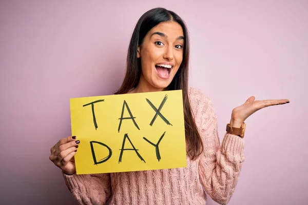 Junge Schöne Brünette Frau Hält Papier Mit Steuertagsmeldung Auf Rosa — Stockfoto