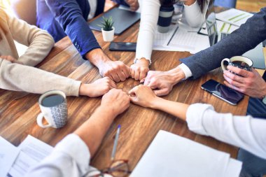 Bir grup işçi ofiste yumruk tokuşturuyor.