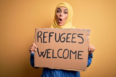 İslami başörtüsü takan güzel bir Arap kadın elinde mültecilerle bayrak tutuyor. Sürpriz bir yüzle şoka girmiş, korku ifadesinden korkan ve heyecanlanan bir mesajı hoş karşılıyor.