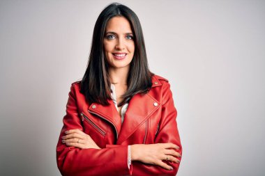 Mavi gözlü, beyaz arka planda kırmızı ceketli, kollarını kavuşturup kameraya gülümseyen esmer bir kadın. Pozitif kişi.