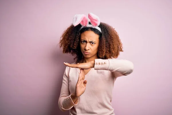 年轻的非洲裔美国女人 有着一头乌黑的耳朵 粉红的背景 手忙脚乱 灰溜溜的 严肃的样子 — 图库照片