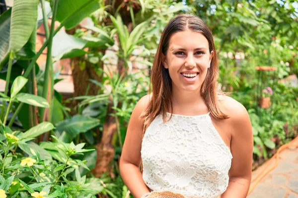 Güneşli bir yaz gününde, kelebek bahçesinde mutlu ve neşeli gülümseyen güzel bir kadın.