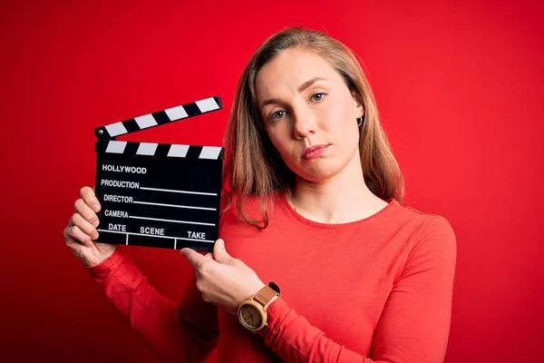 Giovane Bella Bionda Applauso Donna Tenendo Clapboard Sfondo Rosso Isolato — Foto Stock