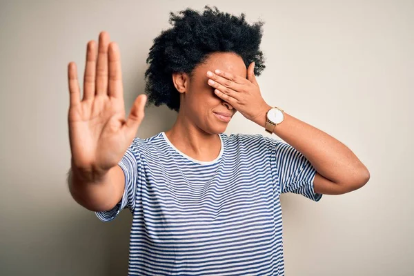 若い美しいアフリカ系アメリカ人のアフロ女性は 手で目を覆う縞模様のTシャツを着て 悲しいと恐怖の表現でジェスチャーを停止します 恥ずかしいと否定的な概念 — ストック写真