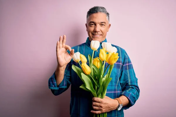 Mittelalter Grauhaarige Mann Hält Natürlichen Strauß Gelber Tulpen Über Rosa — Stockfoto