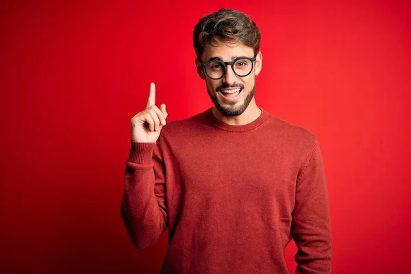 Sakallı Gözlüklü Süveterli Genç Kırmızı Arka Planda Duran Yakışıklı Adam — Stok fotoğraf