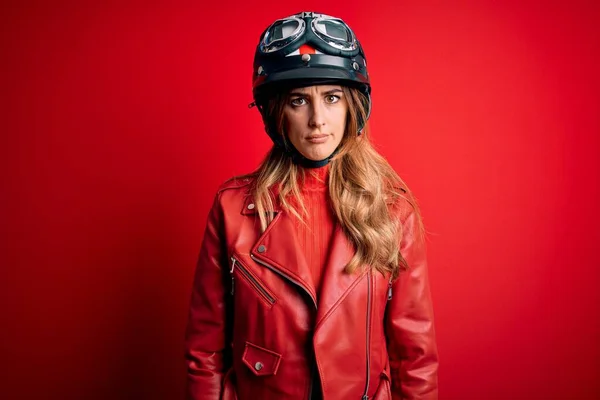 若い美しいブルネットのオートバイの女性は 問題のために動揺を眉をひそめて 赤の背景懐疑的かつ神経の上に元ヘルメットを身に着けている 負の人 — ストック写真