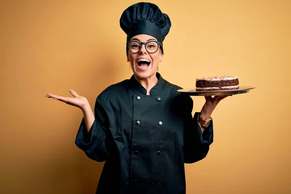 Junge Schöne Brünette Bäckerin Trägt Kochuniform Und Hut Mit Kuchen — Stockfoto