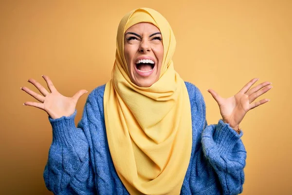年轻美丽的黑发穆斯林女子 头戴阿拉伯头巾 头戴黄褐色头巾 疯疯癫癫地大喊大叫 带着咄咄逼人的表情和胳膊 沮丧的概念 — 图库照片