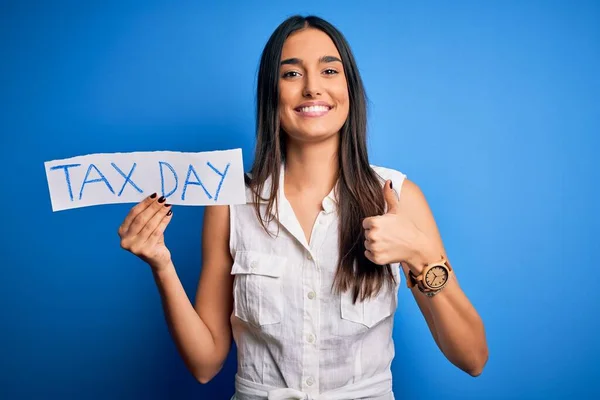 Junge Schöne Brünette Frau Hält Papier Mit Steuertagsmeldung Über Blauem — Stockfoto