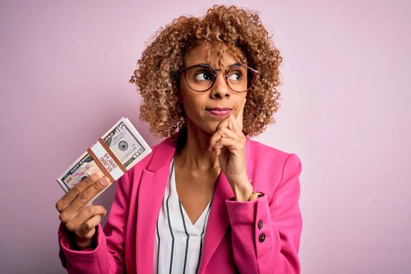 아프리카 미국인 곱슬머리의 분홍색 지폐를 질문에 심각하게 생각하는 — 스톡 사진