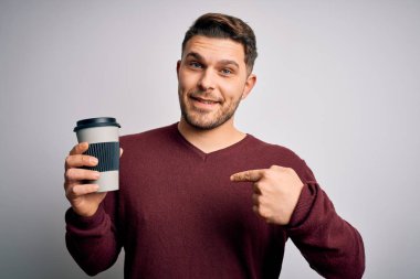 Mavi gözlü genç adam izole edilmiş arka planda plastik şişeden kahve içiyor.