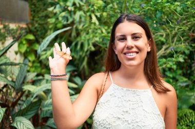 Güneşli bir yaz gününde, kelebek bahçesinde mutlu ve neşeli gülümseyen güzel bir kadın.