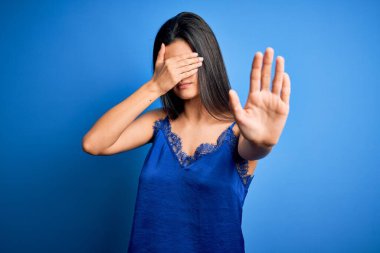 Zarif ve rahat mavi iç çamaşırı giyen genç, güzel esmer kadın gözlerini ellerle kapatıyor ve üzgün ve korku ifadeleriyle jest yapıyor. Utanç verici ve olumsuz bir kavram..