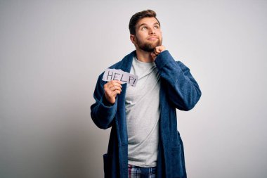 Sakallı, mavi gözlü, elinde pijama kâğıdı olan genç, sarışın bir adam. Yüzünde ciddi bir mesaj taşıyor. Soru sormayı düşünüyor.